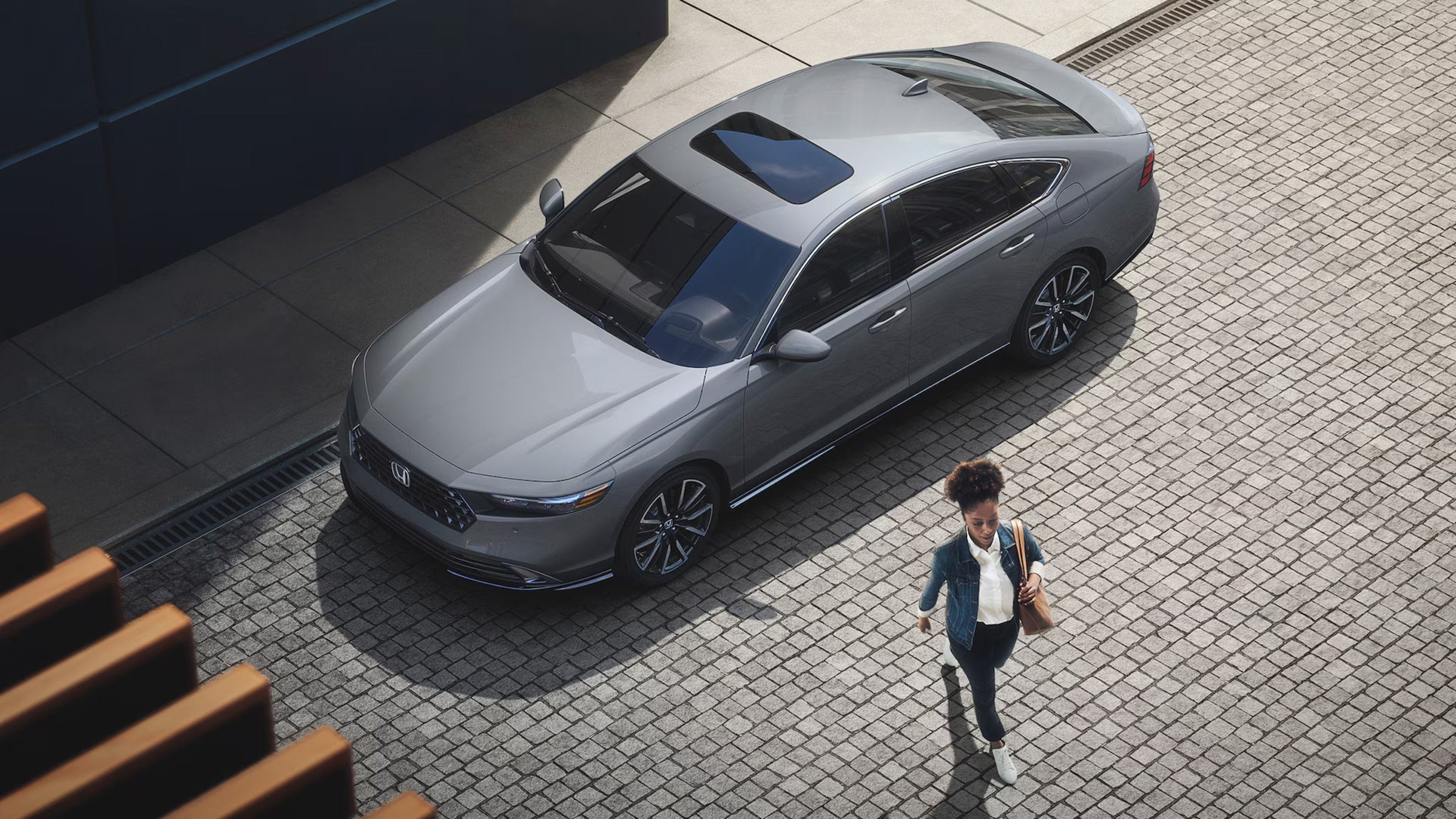 A woman walking away from a silver car.
