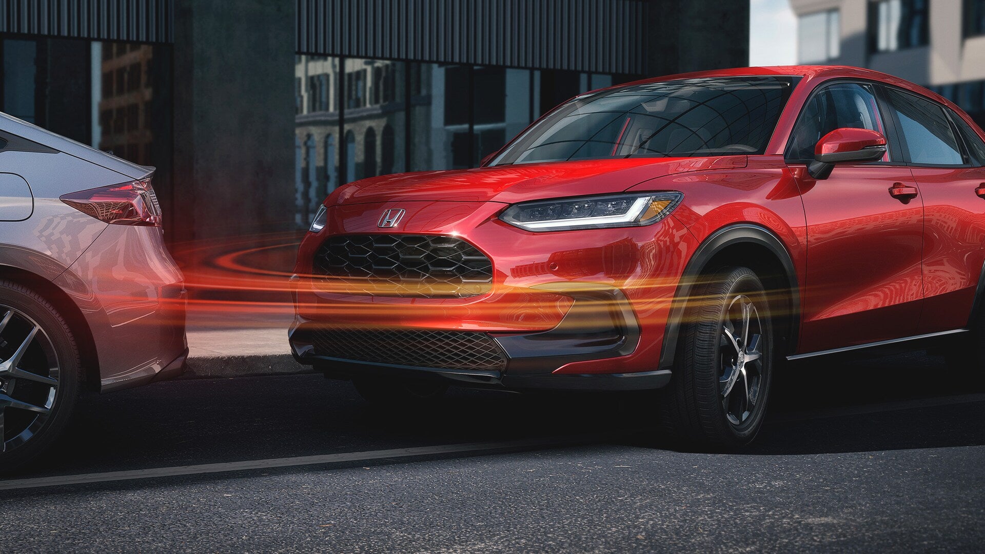 a red honda hr-v parrallel parking and showcasing peace of mind with parking assist