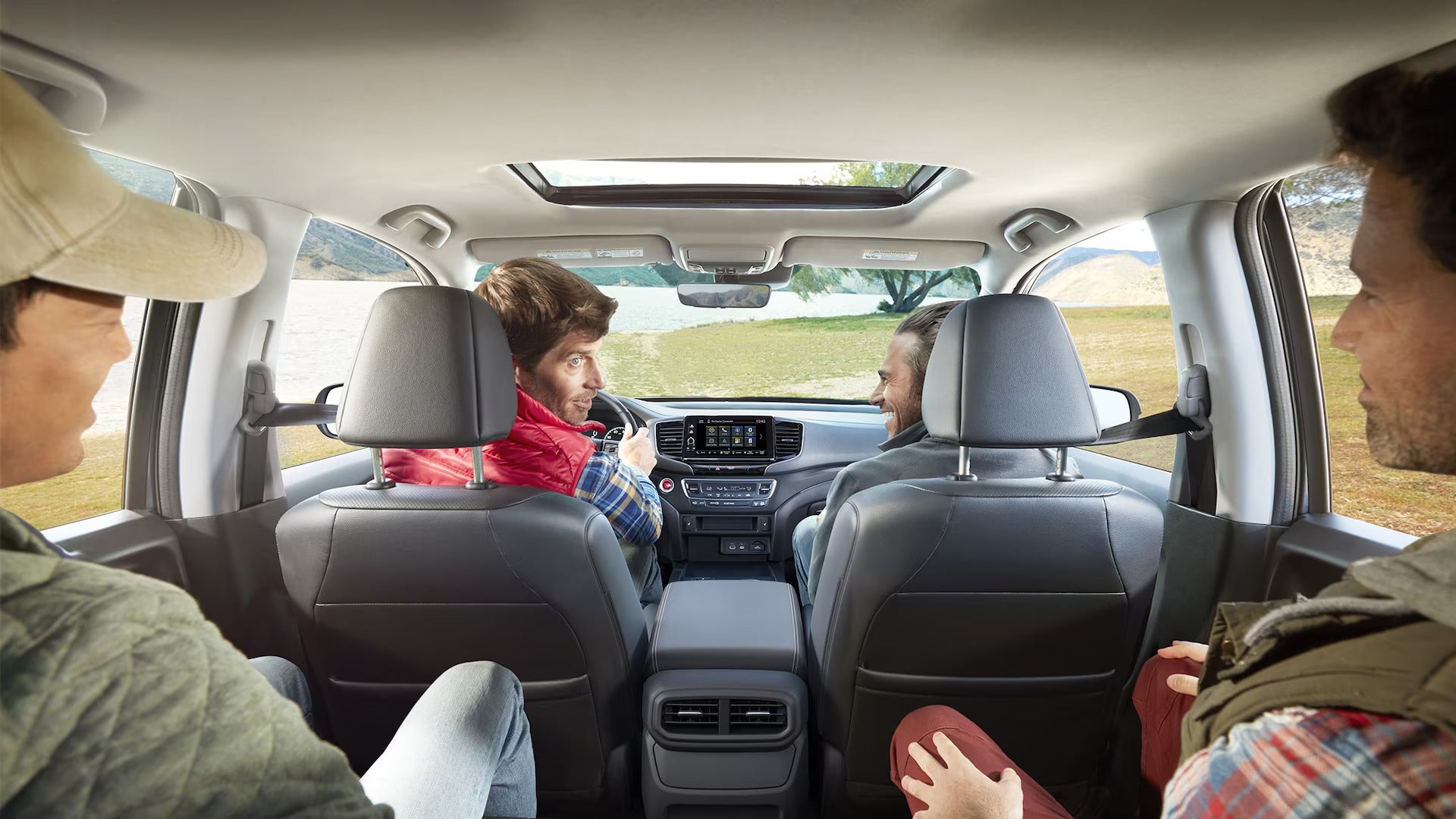 2025 Honda Ridgeline RTL in Black interior with four men sitting in car at campsite.