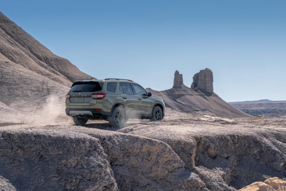 A green pilot driving in the desert.