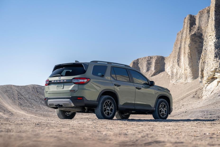 A green pilot sitting parked in the desert.