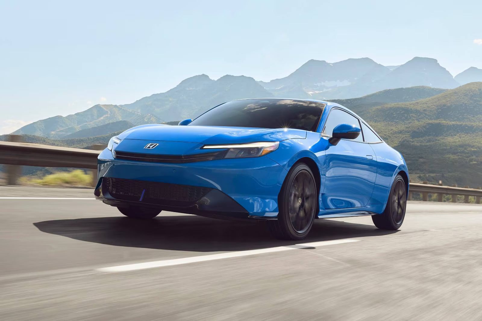 A blue prelude driving on the road.