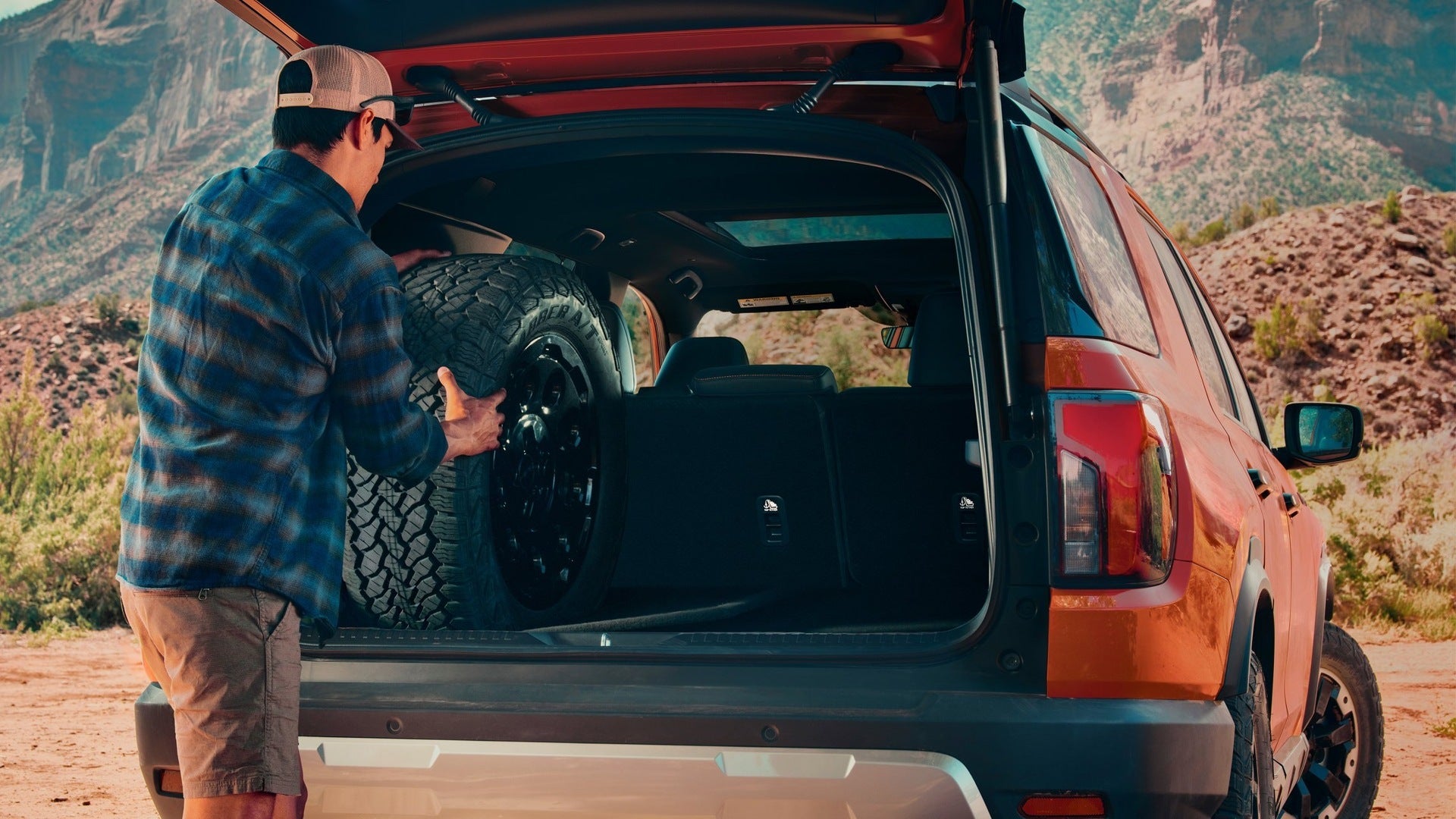 A man getting something from the trunk of a suv.