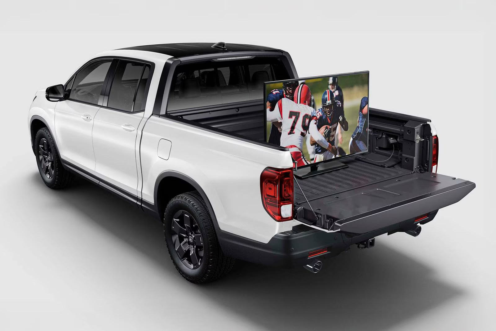 A ridgeline with a tv in the bed.