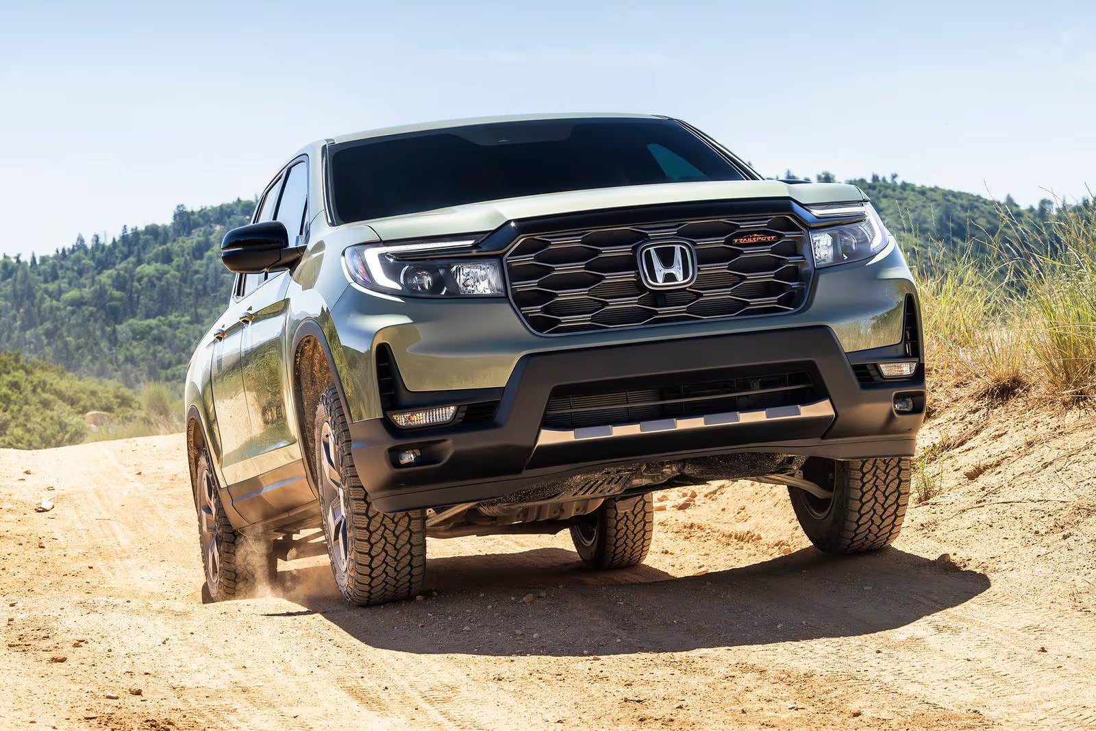 A green truck driving off-road.