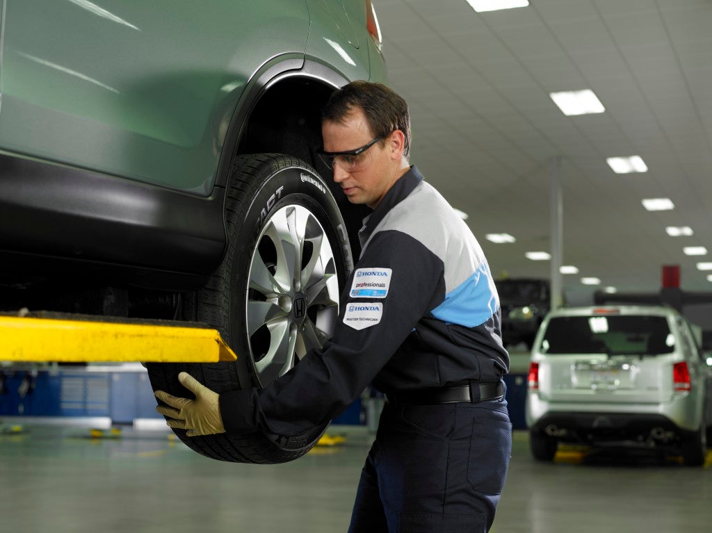 A man working on the tire of a car.