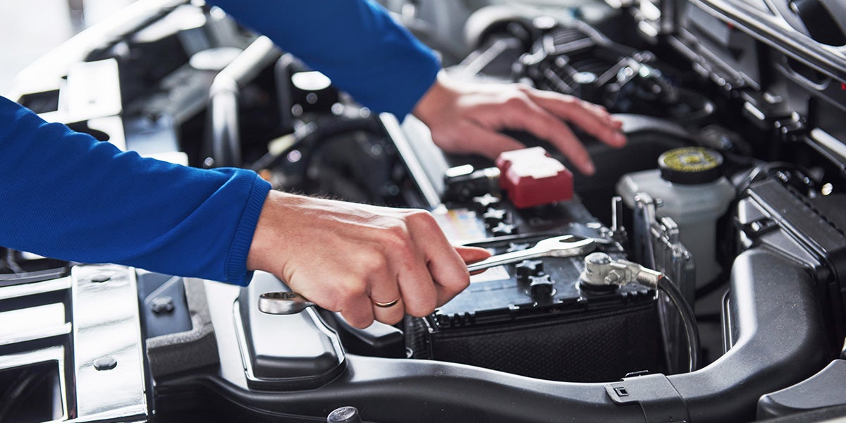 A man working on the battery of a car.
