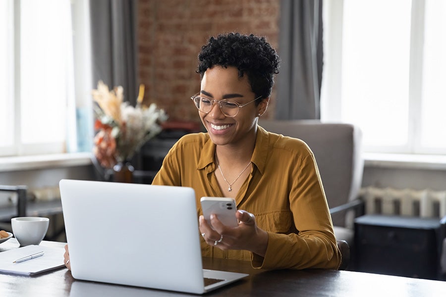 A woman sitting at the computer smiling.