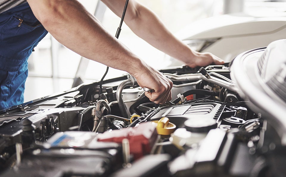 A man working on the engine of a car.